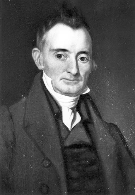 Black and white portrait of Maxwell Chambers, a white man in a dark suit with white neck covering.